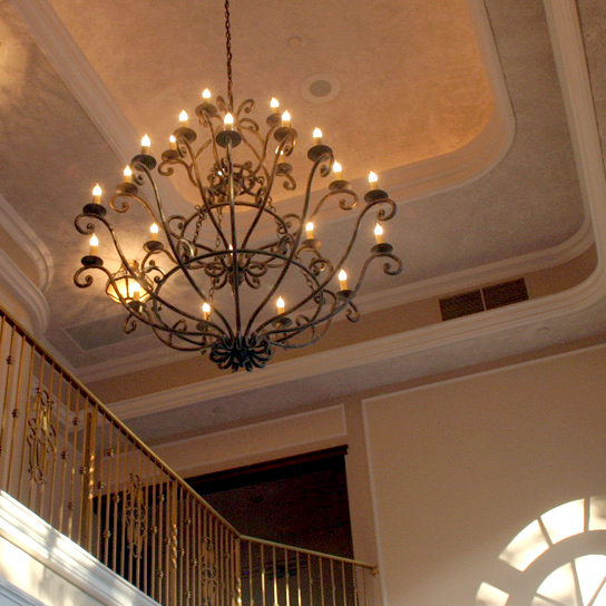 An elegant chandelier hanging in a stairwell.