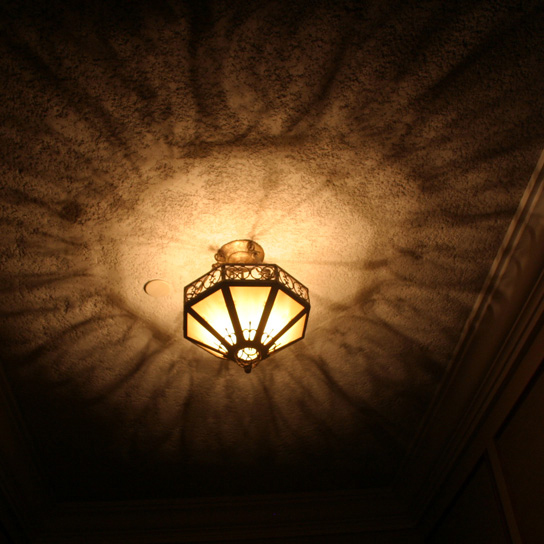 A metal lantern casting shadows across the ceiling.